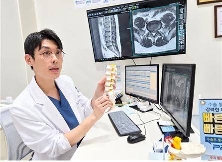 서울본원병원 척추센터 박성철 병원장(정형외과 전문의)이 요추 모형과 MRI 영상을 활용해 허리 통증의 원인과 치료 방법을 설명하고 있다. 서울본원병원 제공)