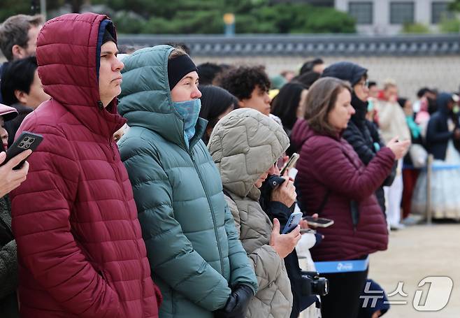 29일 오후 서울 종로구 경복궁 흥례문 광장을 찾은 외국인 관광객들이 두터운 패딩을 입은 채 궁궐 호위군 사열의식 '첩종' 리허설 행사를 지켜보고 있다. 2026.10.29 ⓒ 뉴스1 오대일 기자