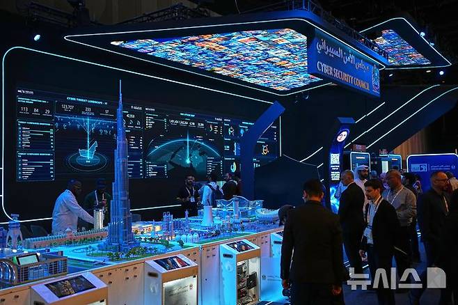 [두바이=AP/뉴시스] 2026년 9월18일 아랍에미리트(UAE) 두바이에서 열린 사이버 보안 전시회 ‘GISEC 글로벌’의 UAE 사이버보안위원회 전시관에서 관람객들이 디지털 화면 아래 모여 있다. 옆 화면에는 사이버 공격 현황을 보여주는 ‘UAE 공격 지도’가 표시돼 있다. 2026.09.18.