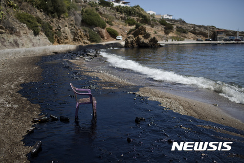 【아테네( 그리스) = AP/뉴시스】 = 아테네에서 가까운 살라미나섬 해안이 기름으로 오염된 채 플래스틱 의자 하나만 서 있다. 소형 유조선 한 척이 10일 침몰해 기름이 유출되고 있다며 그리스 당국은 이 일대 모든 해수욕장의 해수욕객들에게 대피령을 내렸다.