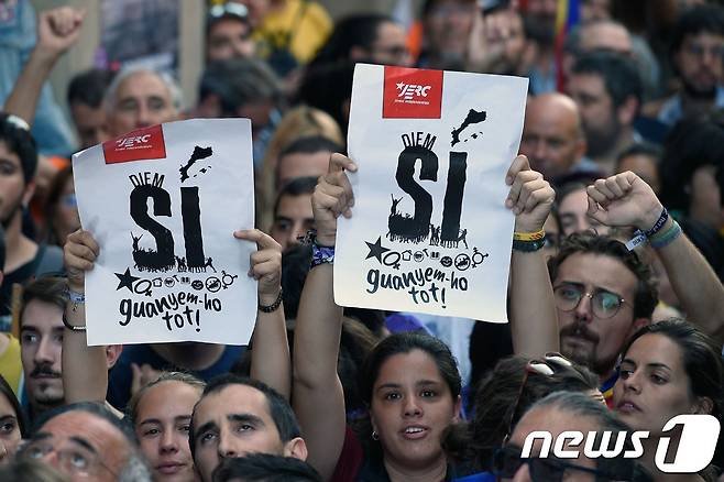 20일(현지시간) 바르셀로나에서 카탈루냐 독립투표를 지지하는 시민들이 '예(Sí)'라고 적힌 종이를 들고 시위를 벌이고 있다. © AFP=뉴스1