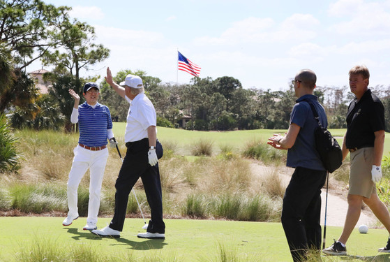 지난 2월 미일 정상회담을 위해 방미한 아베 신조 일본 총리(왼쪽)가 도널드 트럼프 대통령과 골프를 즐기고 있다. [플로리다 교도=연합뉴스] A photo from U.S. President Donald Trump's Twitter shows he and Prime Minister Shinzo Abe giving each other high-five during their golfing in Florida on Saturday. | KYODO