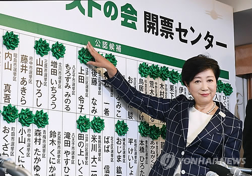 (도쿄 AP=연합뉴스) 고이케 유리코 일본 도쿄 도지사가 지난 7월 2일(현지시간) 실시된 도쿄도 의회 선거에서 당선이 확정된 후보들의 이름에 장미 리본을 달며 미소짓고 있다.