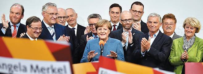 앙겔라 메르켈(가운데) 독일 총리가 24일(현지 시각) 치러진 총선 출구조사 결과, 자신이 이끄는 기독민주당(CDU)·기독사회당(CSU) 연합이 승리한 것으로 나타나자 베를린 당사에서 밝은 표정으로 연설하고 있다. 이번 선거로 메르켈 총리는 4연임(連任)에 성공했으나 극우 성향 정당인‘독일을 위한 대안(AfD)’이 연방 하원 내 3당에 오르는 등 돌풍을 일으키면서 향후 국정 운영에 어려움을 겪을 것으로 보인다. /AFP 연합뉴스