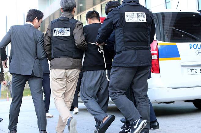 맨발에 슬리퍼를 신은 이영학씨가 13일 오전 서울 중랑경찰서에서 기자들의 질문에 답한 뒤 호송차로 이동하고 있다. 이씨의 양팔이 포승줄에 묶여있다. 조문규 기자