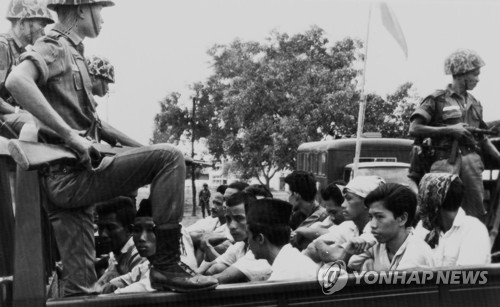1965년 10월 30일 인도네시아 자카르타 시내에서 공산당(PKI) 소속 청년단원이란 의심을 받는 젊은이들이 군인들의 감시 속에 교도소로 옮겨지고 있다. [AP=연합뉴스]