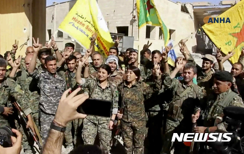 【AP/뉴시스】미군의 지원을 받는 시리아 민주군(SDF) 군인들이 10월17일 극단이슬람 무장조직 이슬람국가(IS) 수도 격이 락까를 탈환한 후 손가락으로 승리의 브이(V)자를 만들어 보이고 있다. 2017.10.18