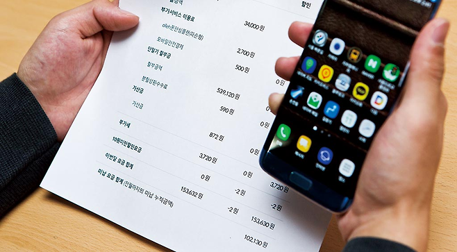 한 스마트폰 사용자가 통신비 고지서에 적힌 단말기 할부금을 확인하고 있다. © 시사저널 최준필