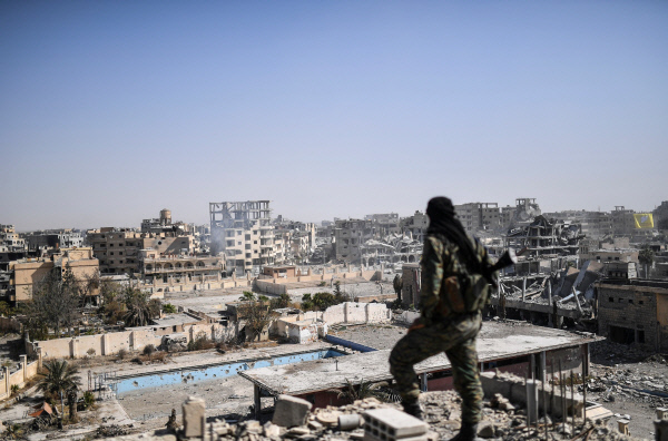 이슬람국가(IS)의 상징적 수도였던 시리아 락까를 함락시킨 시리아민주군(SDF) 소속 병사가 지난 20일 락까 시내 한 건물의 옥상에 올라가 시내를 내려다보고 있다. 락까|AFP연합뉴스