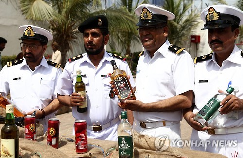 지난해 5월 파키스탄 남부 카라치에서 파키스탄해상경비대가 압수한 술병을 들어보이고 있다.[EPA=연합뉴스 자료사진]
