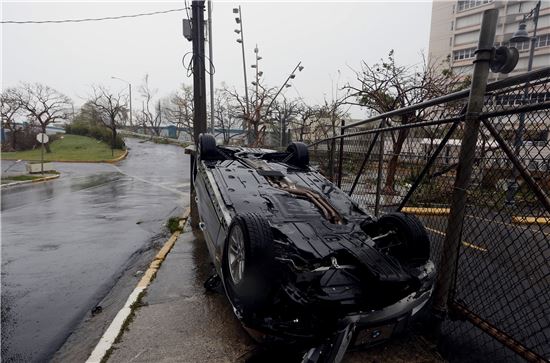 9월 20일(현지시간) 허리케인 마리아가 덮친 푸에르토리코 산주안 도로 위에 차량 한 대가 강풍으로 뒤집혀 있다.(사진출처=EPA연합)