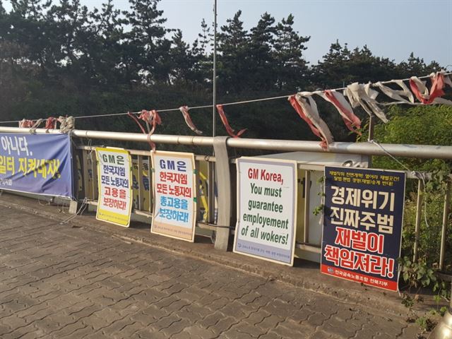 24일 전북 군산의 한국지엠 생산공장 주변에 비정규직 노조원들이 내건 플래카드가 걸려있다.