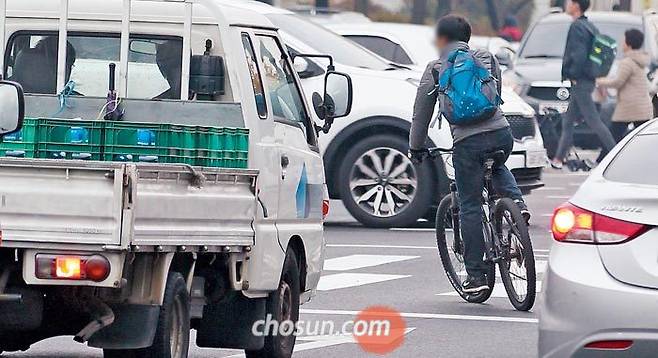 7일 오전 서울 도봉구 방학사거리 인근 도로에서 자전거 운전자가 2차로와 3차로의 차들 사이로 빠져나와 자전거를 탄 채 횡단보도를 건너려 하고 있다. 방학사거리 부근은 지난해 서울에서 자전거 교통사고가 가장 자주 일어난 곳으로 많은 자전거들이 자전거·보행자겸용도로 대신 차로를 달리고 있었다. /장련성 객원기자