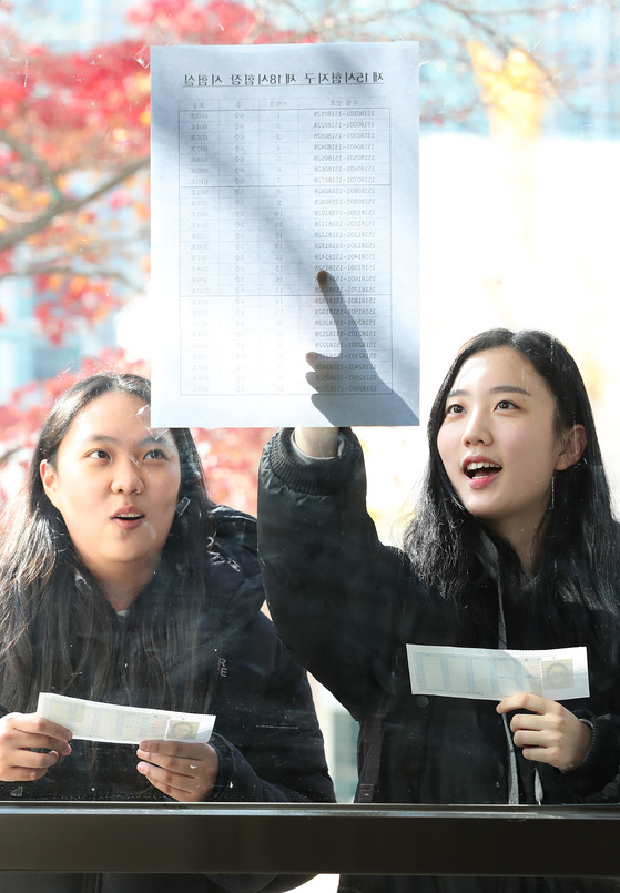 서울 정동 이화여고에서 수험생들이 수험표를 들고 시험실 배치표를 확인하고 있다. 우상조 기자