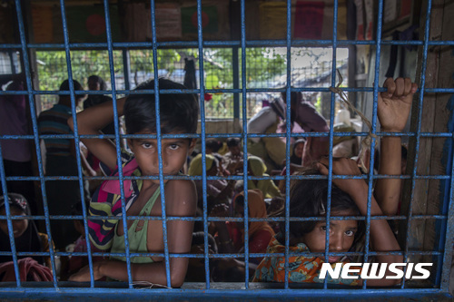【 쿠투팔롱 = AP/뉴시스】 사선을 넘어 방글라데시로 탈출한 미얀마 로힝야 어린이들이 쿠투팔롱 난민수용소에서 철조망 밖을 바라보고 있다.  유니세프는 11월 20일로 제정한 세계 아동의 날을 맞아 어린이들이 주도하는 어린이를 위한, 어린이의 생명을 구하는 행사를 전 세계적으로 거행할 것이라고 14일(현지시간) 유엔본부에서 밝혔다. 2017.11.15