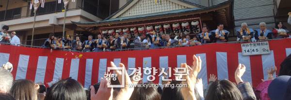 일본의 한 신사에서 열린 마쓰리에서 제단 위에 있는 사람들이 복을 기원하며 사탕, 과자 따위를 던지자 아래 있는 사람들이 이를 받기 위해 손을 뻗고 있다.