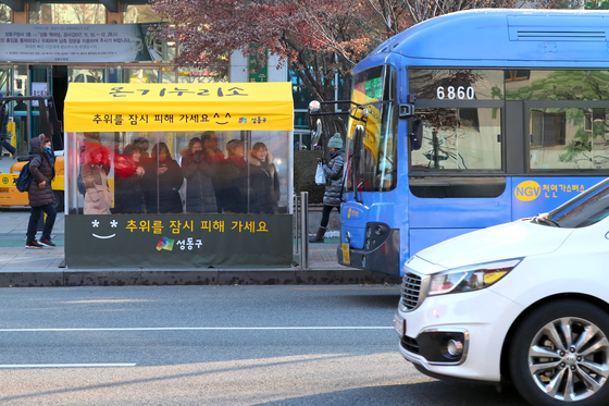 서울 성동구청 앞 버스정류장에 설치된 '온기누리소'. 최강 한파가 찾아온 12일 아침 버스를 기다리는 시민들이 텐트 안에서 추위를 피하고 있다.［사진 성동구청］
