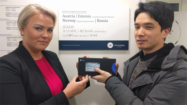 지난 15일 서울 브이에프에스코리아 사무실에서 김용대 씨(오른쪽)가 에스토니아 출입국 관리 직원으로부터 전자주민증을 받고 있다.