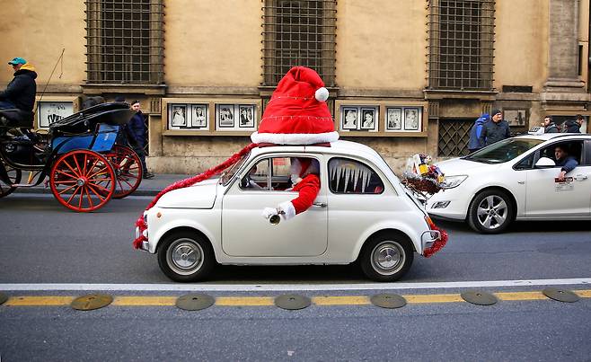 지난 9일(현지시간) 자동차를 타고 이탈리아 로마 시내를 지나고 있는 산타클로스.[로이터=연합뉴스]