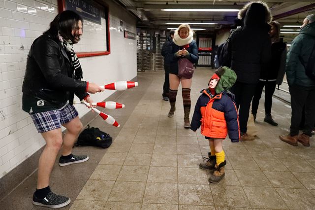 17번째 '바지 안 입고 지하철 타기'(No Pants Subway Ride)행사가 열린 뉴욕 지하철에서 한 승객이 속옷을 입고 저글링을 하자 꼬마가 신기한 표정을 지켜보고 있다.뉴욕=로이터연합뉴스