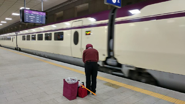 SRT 열차가 수서역에 진입하자 고개 숙여 인사하는 청소노동자. 경향신문 독자 박준규씨 제공
