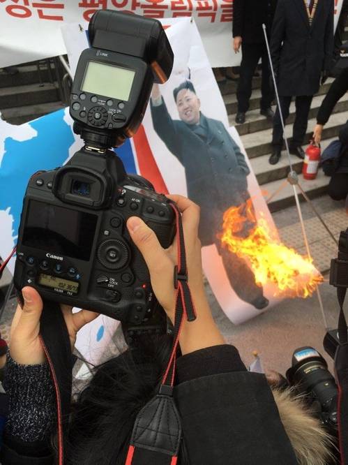 (서울=연합뉴스) 사건팀 = 현송월 삼지연 관현악단 단장이 이끄는 북한 예술단 사전 점검단이 서울역에 도착한 22일 오전 서울역에서 보수단체가 인공기와 김정은 사진 화형식을 하고 있다. 2018.1.22.