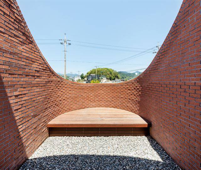 거실에서 본 펠리컨 부리. 중간에 멀리 소나무 숲이 간신히 걸린다. 곡면에 맞춰 평상을 짜 넣어 야외 모임공간으로 쓸 수 있다. 신경섭 건축사진작가 제공