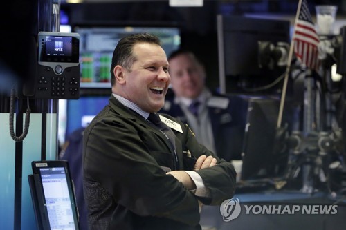 미국 뉴욕증권거래소(NYSE)에서 모니터를 보며 환하게 웃고 있는 트레이더 모습.[AP=연합뉴스]