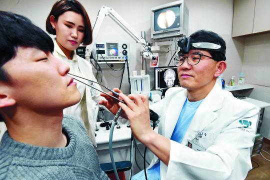 하나이비인후과병원 정도광 원장이 코감기를 앓은 뒤 급성 축농증을 합병했을 것으로 의심되는 한 환자의 콧속을 내시경으로 샅샅이 훑어보고 있다. 이병주 기자