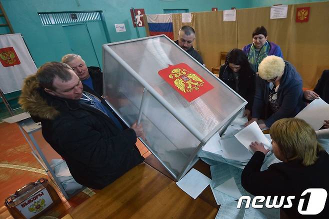 18일(현지시간) 러시아의 한 투표소에서 투표함이 비워지고 있다. ? AFP=뉴스1