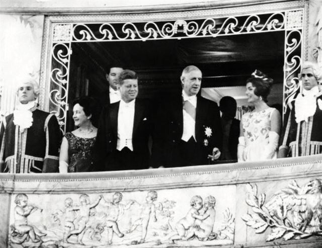 1961년 6월 케네디 대통령의 베르사유 궁 방문 기념 저녁 식사를 앞두고 영부인 재클린 케네디가 발코니에 모습을 드러냈다. 재클린이 입은 아이보리색 프린세스 드레스는 이 날을 위해 지방시가 특별 제작했다. 몸에 달라붙는 민소매 상의에 은방울꽃과 장미가 정교하게 수놓아져 있다. 왼쪽에서 세 번째부터 순서대로 존F. 케네디 미국 대통령, 샤를 드골 프랑스 대통령, 재클린 케네디 영부인. <보그 온: 위베르 드 지방시> 51books 제공.