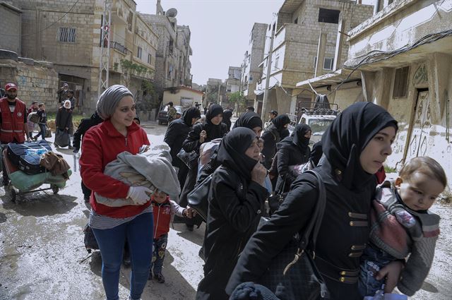 시리아 동구타 지역에 거주하던 주민들이 24일 정부군과 반군의 합의로 설정된 안전지대를 통해 동구타에서 탈출하고 있다. 다마스쿠스=EPA 연합뉴스