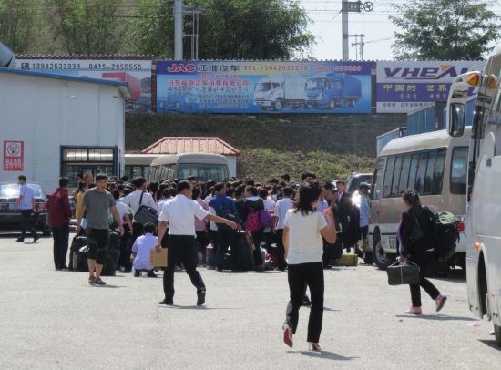 지난해 9월 12일(현지시간) 북중 접경인 중국 랴오닝(遼寧)성 단둥(丹東)의 해관 주차장에 북한으로 돌아가려는 북한 노동자들이 모여 있다(사진=연합뉴스).