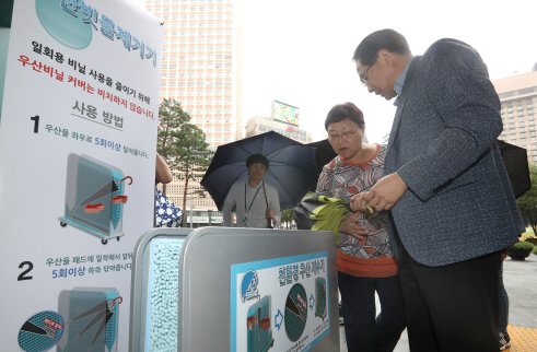 서울 시청 입구에 우산 빗물 제거기가 설치되어 시민들이 이용하고 있다.(사진=연합뉴스)