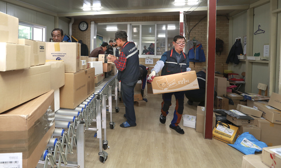 실버 택배 기사들이 경로당에 도착한 택배 물품을 분류하고 있다. 임현동 기자