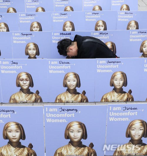 【서울=뉴시스】권현구 기자 = 지난달 7일 오후 서울 종로구 옛 일본대사관 앞에서 열린 일본군 위안부 문제 해결을 위한 1325차 정기 수요시위에서 관계자들이 수요집회에 참석하지 못하는 시민들의 얼굴을 소녀상과 합성하는 'UNCOMFORT WOMEN' 퍼포먼스를 하고 있다. 2018.03.07. stoweon@newsis.com