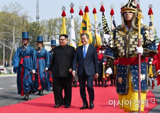 문재인 대통령과 김정은 북한 국무위원장이 27일 오전 판문점 군사분계선에서 만나 공식 환영식장으로 이동하고 있다. /한국공동사진기자단