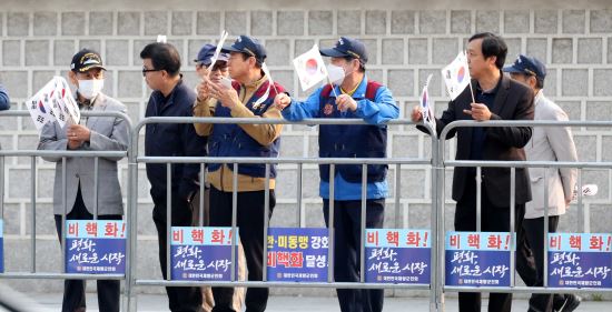 재향군인회원들이 27일 서울 종로구 거리에서 태극기와 한반도 평화 기원 팻말을 들고 문재인 대통령의 차량 행렬을 기다리고 있다. 뉴시스