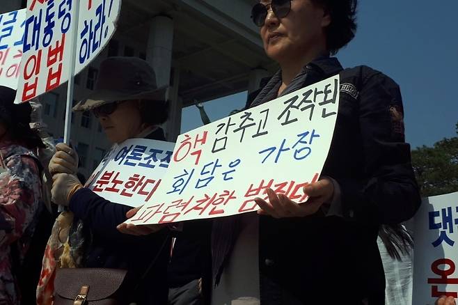 한 자유한국당 지지자가 29일 댓글조작 규탄 및 특검 촉구대회에 참석해 손팻말을 들고 있다. ⓒ조혜지