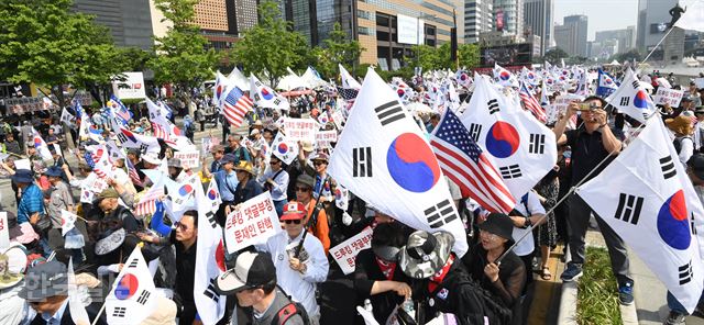 6일 오후 서울 종로구 교보빌딩 앞에서 열린 '자유민주주의 수호 국민대회'에서 참여자들이 태극기와 성조기를 들고 행진 하고 있다. 배우한 기자