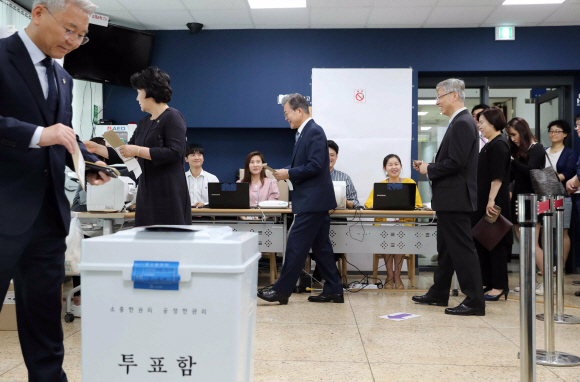 줄 서서 투표하는 文대통령 - 문재인(오른쪽) 대통령과 김정숙(가운데) 여사가 6·13 지방선거 사전투표 첫날인 8일 서울 종로구 삼청동주민센터에서 유권자와 함께 줄을 서서 투표 용지를 받고 있다. 2013년 사전투표가 도입된 이후 현직 대통령이 전국 단위 선거에서 사전투표에 참여한 것은 이번이 처음이다. 투표율은 4년 전 지방선거 사전투표(4.75%) 때보다 높은 것으로 나타났다. 안주영 기자 jya@seoul.co.kr