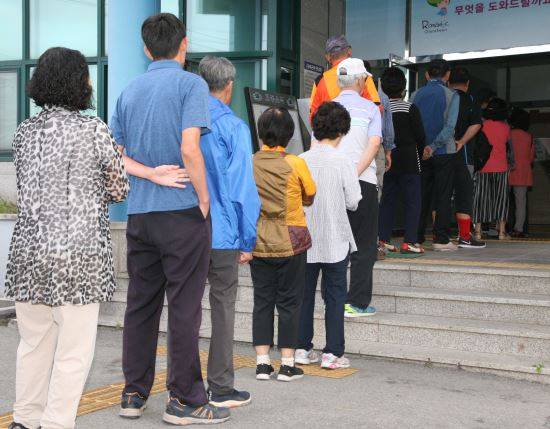 13일 오전 6시 제7회 전국동시지방선거 본투표가 시작된 가운데 강원 춘천시 교동주민센터에 설치된 투표소에서 첫 투표자가 소중한 한표를 행사하고 있다.