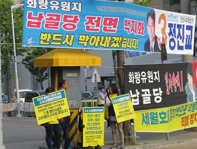 세월호 추모공원을 '납골당'으로 표기한 보수 야당 후보자들의 홍보물 앞에서 진실 알리기 캠페인을 펼치고 있는 세월호 유가족들 ⓒ성하훈