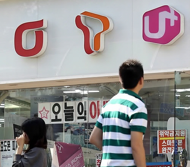 이통사의 로고가 보이는 한 판매점 앞으로 시민이 지나가고 있다. ⓒ 연합뉴스