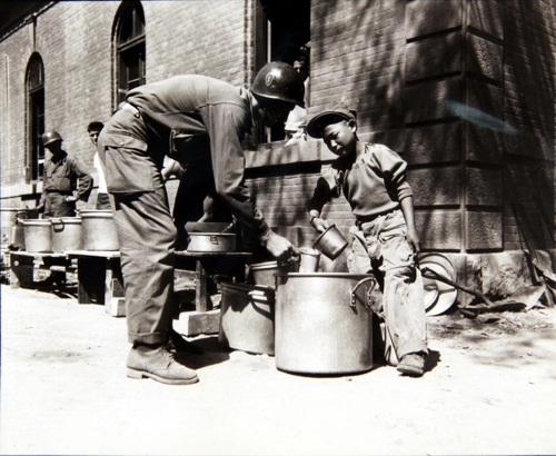 미군에게 커피를 따라주는 한 소년. 이들은 '부대 마스코트'로 불렸다. 1950년 9월 23일 촬영됐다.[국사편찬위 제공=연합뉴스]
