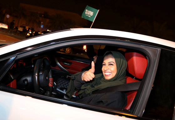 사우디 여성 운전자가 24일(현지시간) 새벽 알 코바르 시내에서 운전하며 엄지 손가락을 펴보이 고 있다. [로이터=연합뉴스]