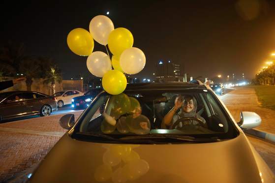 한 사우디 여성이 24일(현지시간) 코바르 시내 중심 도로에서 그녀의 친구들과 자신의 첫번째 운전을 축하하고 있다. [AFP=연합뉴스]