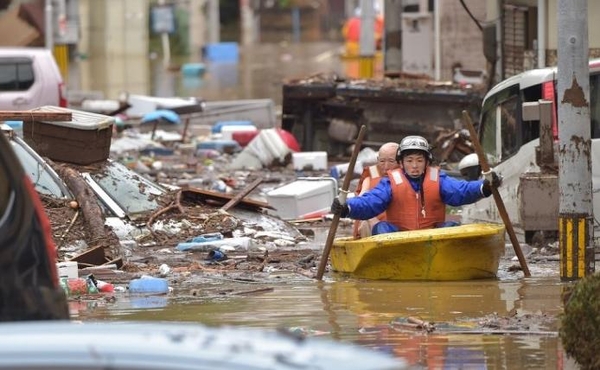 일본 구조대원이 호우 지역의 주민을 구출하고 있다. /마이니치 신문