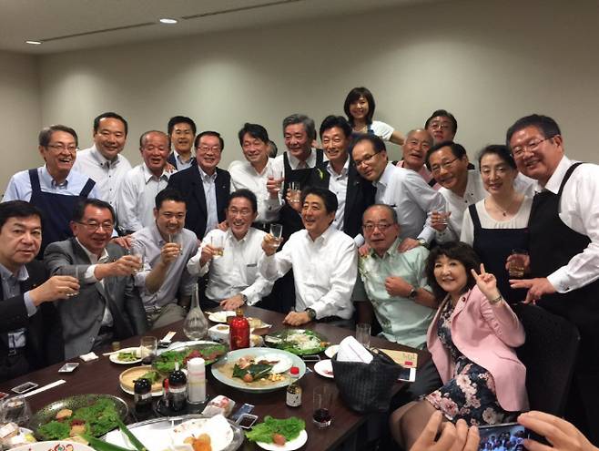 아베 신조 일본 총리(가운데)와 자민당 의원들이 지난 5일 도쿄에서 만찬 간담회를 하며 술잔을 들고 기념사진을 찍고 있다. 니시무라 야스토시 관방 부장관 트위터 캡처