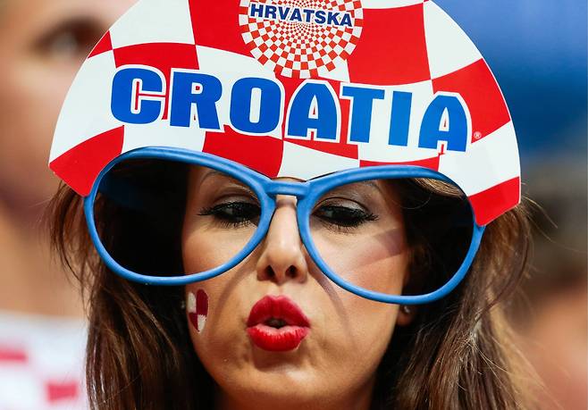 크로아티아 축구 팬이 국기의 체크무늬로 디자인한 모자를 쓰고 키스를 보내고 있다. [TASS=연합뉴스]